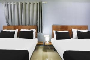 two beds sitting next to each other in a room at Townhouse RIO in Hyderabad