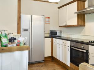 a kitchen with white cabinets and a refrigerator at Riverview - Ioj in Brandesburton