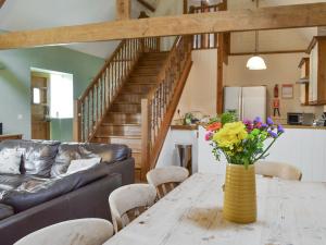 a living room with a table with flowers in a yellow vase at Riverview - Ioj in Brandesburton