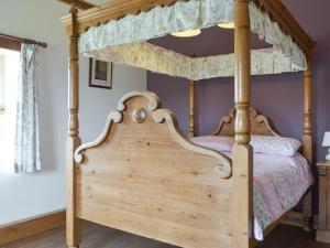 a canopy bed with a wooden frame in a bedroom at Riverview - Ioj in Brandesburton
