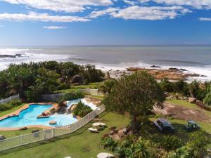 an aerial view of a swimming pool and the beach at Secret Sands Glenmore Beach in Port Edward