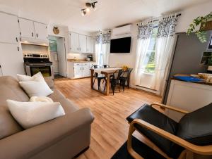 a living room with a couch and a table at Cozy and Welcoming Chalet with Spa in Saint-Tite-des-Caps
