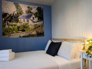 a bedroom with a bed with a painting on the wall at Cozy and Welcoming Chalet with Spa in Saint-Tite-des-Caps