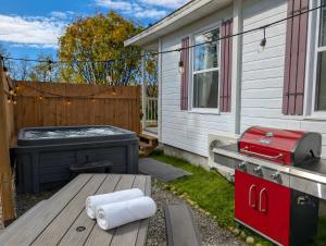 a backyard with a grill and a picnic table at Cozy and Welcoming Chalet with Spa in Saint-Tite-des-Caps