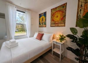 a bedroom with a white bed and a window at Cozy and Welcoming Chalet with Spa in Saint-Tite-des-Caps