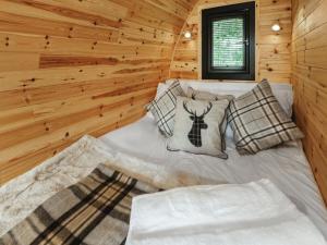 a bed in a room with a wooden wall at Islay - Uk48416 in Dalry