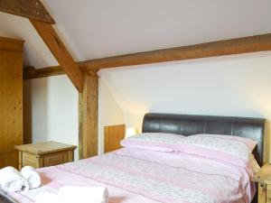 a bedroom with a bed with a black headboard at Broad Leaf - Iok in Brandesburton