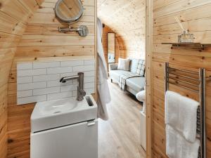 a tiny house bathroom with a sink and a couch at Islay - Uk48416 in Dalry +11 photos