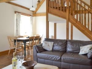 a living room with a leather couch and a table at Broad Leaf - Iok in Brandesburton