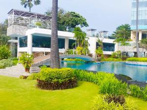 une maison avec une piscine en face d'un bâtiment dans l'établissement The Palm Wongamat Beach Pattaya, à Pattaya (nord)