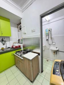 a small kitchen with a stove and a sink at Homestay PANDAN 10 PULAU MELAKA in Malacca