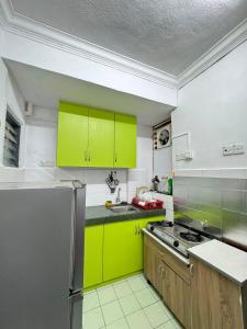 a kitchen with lime green cabinets and a refrigerator at Homestay PANDAN 10 PULAU MELAKA in Malacca