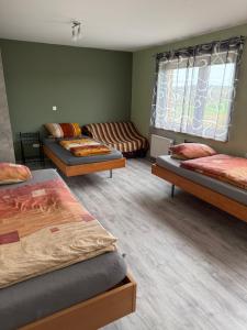a room with three beds and a couch at Sunset BoB Fuldatal in Fulda +12 photos