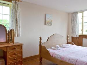 a bedroom with a bed with a dresser and a tv at Four Bays - Ioh in Brandesburton