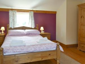 a bedroom with a bed with purple walls and a window at Four Bays - Ioh in Brandesburton +17 photos