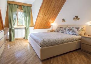 a bedroom with a bed and a large window at Pescasseroli Appartamento Panoramico in Pescasseroli