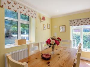 a dining room with a table with a vase of flowers at Edlington Hall Cottage in Edlington
