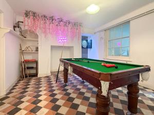 a room with a pool table and a neon sign at West View in Broughton