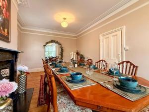 a dining room with a long table with chairs and a fireplace at West View in Broughton +26 photos