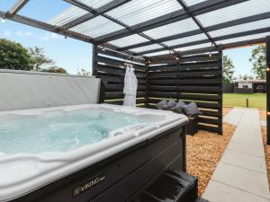 a hot tub in a backyard with a pergola at Arran - Uk48415 in Dalry +9 photos