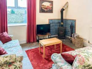 a living room with a table and a wood stove at Clifford Courtyard in Kirkby Stephen