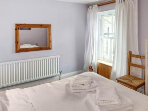 a bedroom with a bed and a mirror and a window at Clifford Courtyard in Kirkby Stephen +8 photos