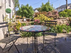 a table and two chairs in a garden at Ty Bobbet in Amlwch
