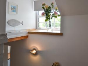 a kitchen with a vase with flowers in a window at Ty Bobbet in Amlwch +19 photos