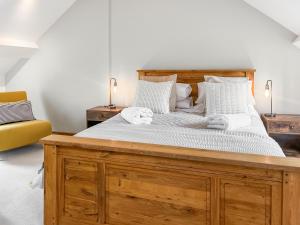 a bedroom with a large wooden bed with white pillows at Bridge Cottage - Ukc9516 in Sheepwash +7 photos