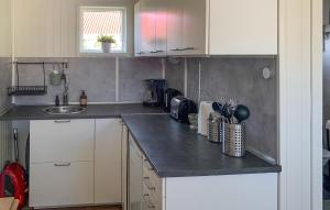 una cucina con mobili bianchi e un piano di lavoro grigio di Splendido Appartamento A Sölvesborg a Sölvesborg