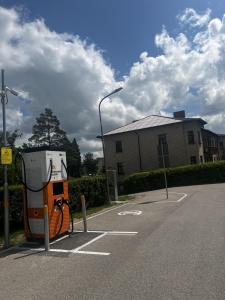 a gas pump in a parking lot next to a building at J&K Apartments in Brocēni