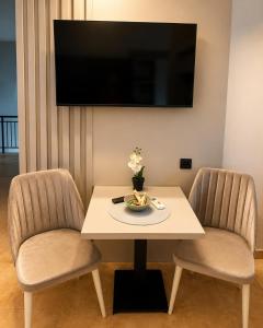 a room with a table and two chairs and a tv at Apartments Sejla in Ulcinj