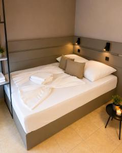a large bed with white sheets and pillows on it at Apartments Sejla in Ulcinj