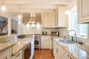 a kitchen with white cabinets and a sink at Private Pool Central AC Dog Friendly in Barnstable