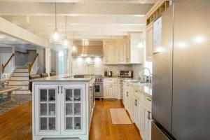 a kitchen with white cabinets and a stainless steel refrigerator at Private Pool Central AC Dog Friendly in Barnstable