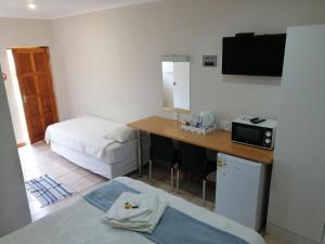 a room with a bed and a desk with a microwave at Twilight Inn in Vryheid