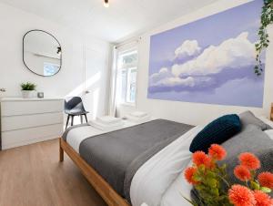 a bedroom with a bed and a mirror and a chair at WOW Chalet Boho - Charlevoix Spa Firepit and BBQ in Saint-Tite-des-Caps