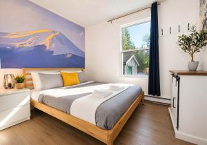 a bedroom with a large bed and a large window at WOW Chalet Boho - Charlevoix Spa Firepit and BBQ in Saint-Tite-des-Caps