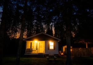a small house with a light on it at night at WOW Chalet Boho - Charlevoix Spa Firepit and BBQ in Saint-Tite-des-Caps