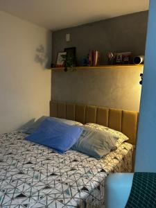 a bed with a blue pillow on top of it at Garanhuns casatres123 in Garanhuns