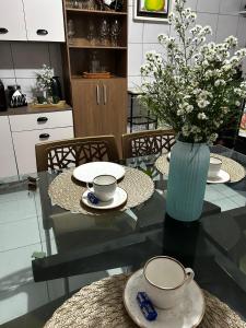 a glass table with a vase with flowers on it at Garanhuns casatres123 in Garanhuns