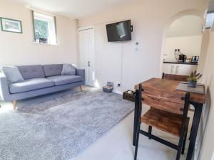 a living room with a couch and a table at Coach House in Beaworthy