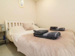 a bedroom with a bed with towels on it at Coach House in Beaworthy