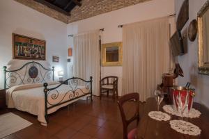 a bedroom with a bed and a table and chairs at Relais del Porto in Cagliari