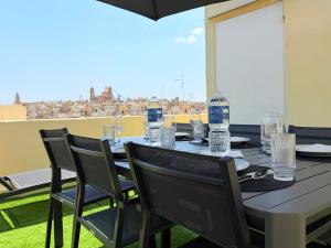 a table with chairs and bottles of water on it at Guesthouse Historical Palacinho de São Antonio in Birgu