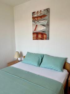 a bedroom with a bed with a painting on the wall at Apartman DMA in Tivat