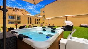 a hot tub sitting on a patio with umbrellas at Hotel de Ilhavo Plaza & Spa in Ílhavo