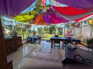 a room with tables and colorful umbrellas at Farmhouse B&B Family stay or Romantic break, on our smallholding close to Narberth in Narberth
