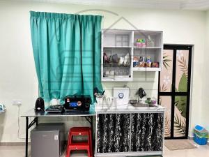 a kitchen with a table and a blue curtain at Dikmad Studio Room Bukit Mentok, Kemaman in Cukai