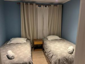 two beds sitting next to each other in a bedroom at HOTEL LOYOLA in Coihaique +20 photos